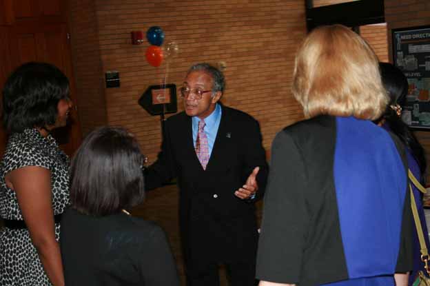 A person in a suit talking to a group of people