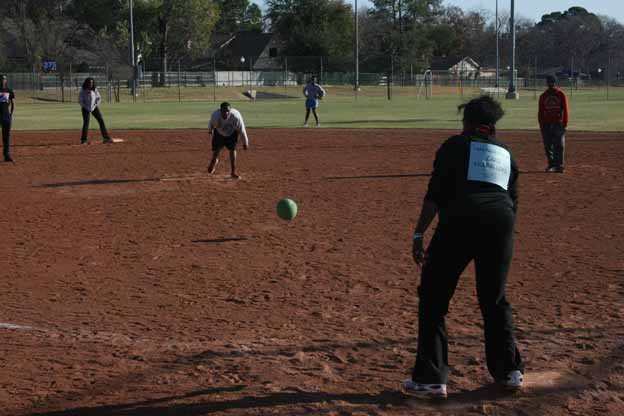 A group of people playing Kickball