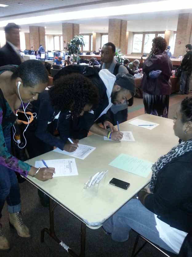 A group of people writing on paper