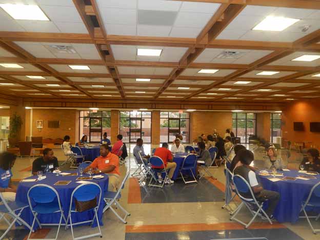 People sitting in a room with tables and chairs