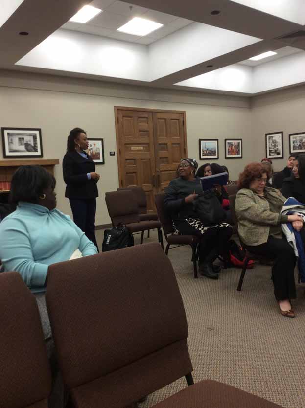 A person standing in a room with a group of people