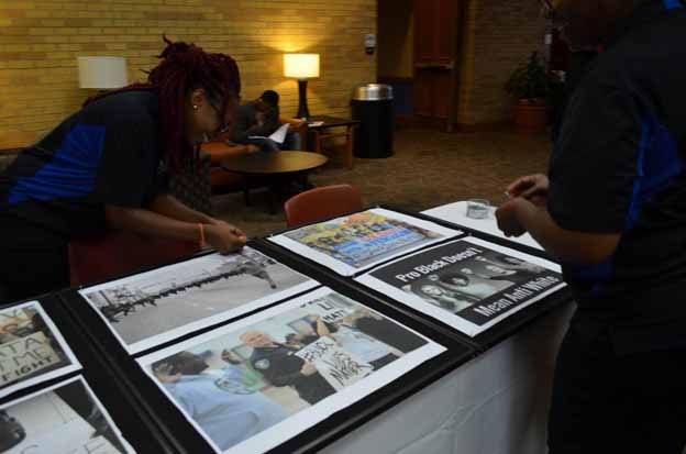 A couple of people looking at posters on a table