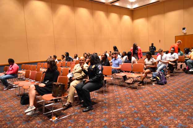 A group of people sitting in chairs in a conference room