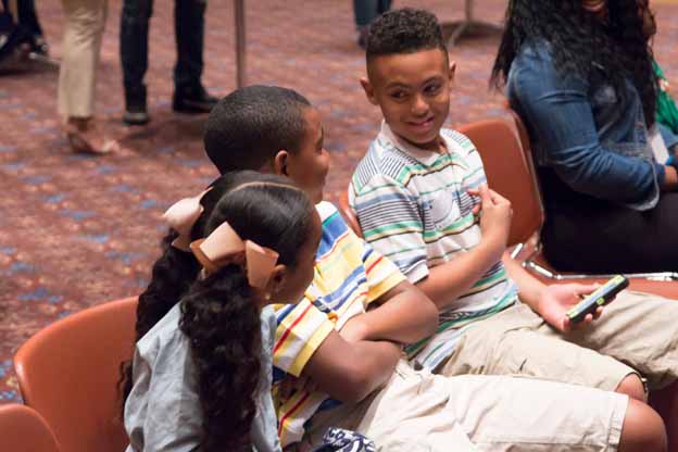 A group of children sitting in chairs