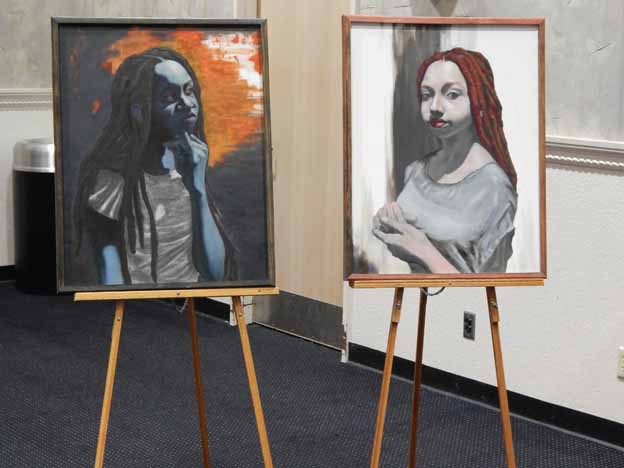 Two easels with paintings on them