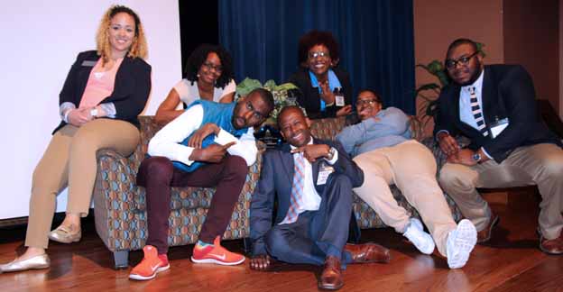 A group of people sitting on a couch posing for a photo